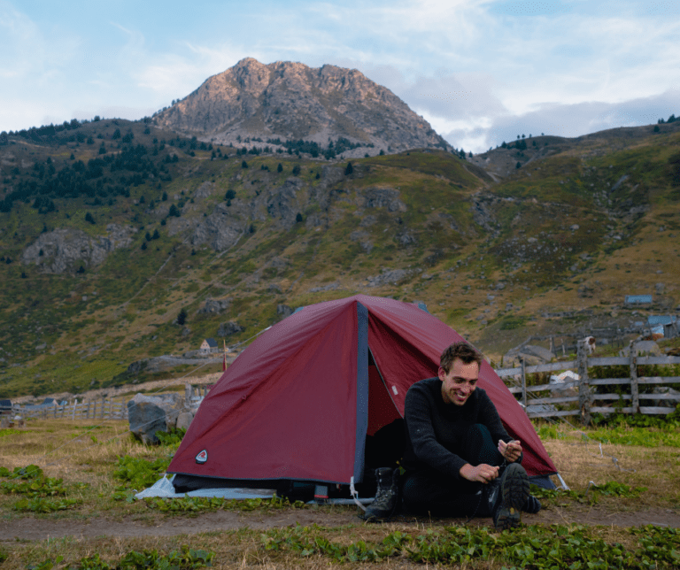 Randonneur voor zijn tent tijdens de trek in de Balkan
