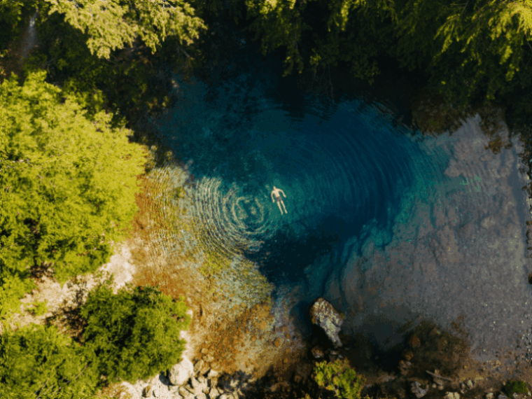 Blue eye en Albanië met een zwemmer tijdens de wandeling op de Peaks of the Balkans.