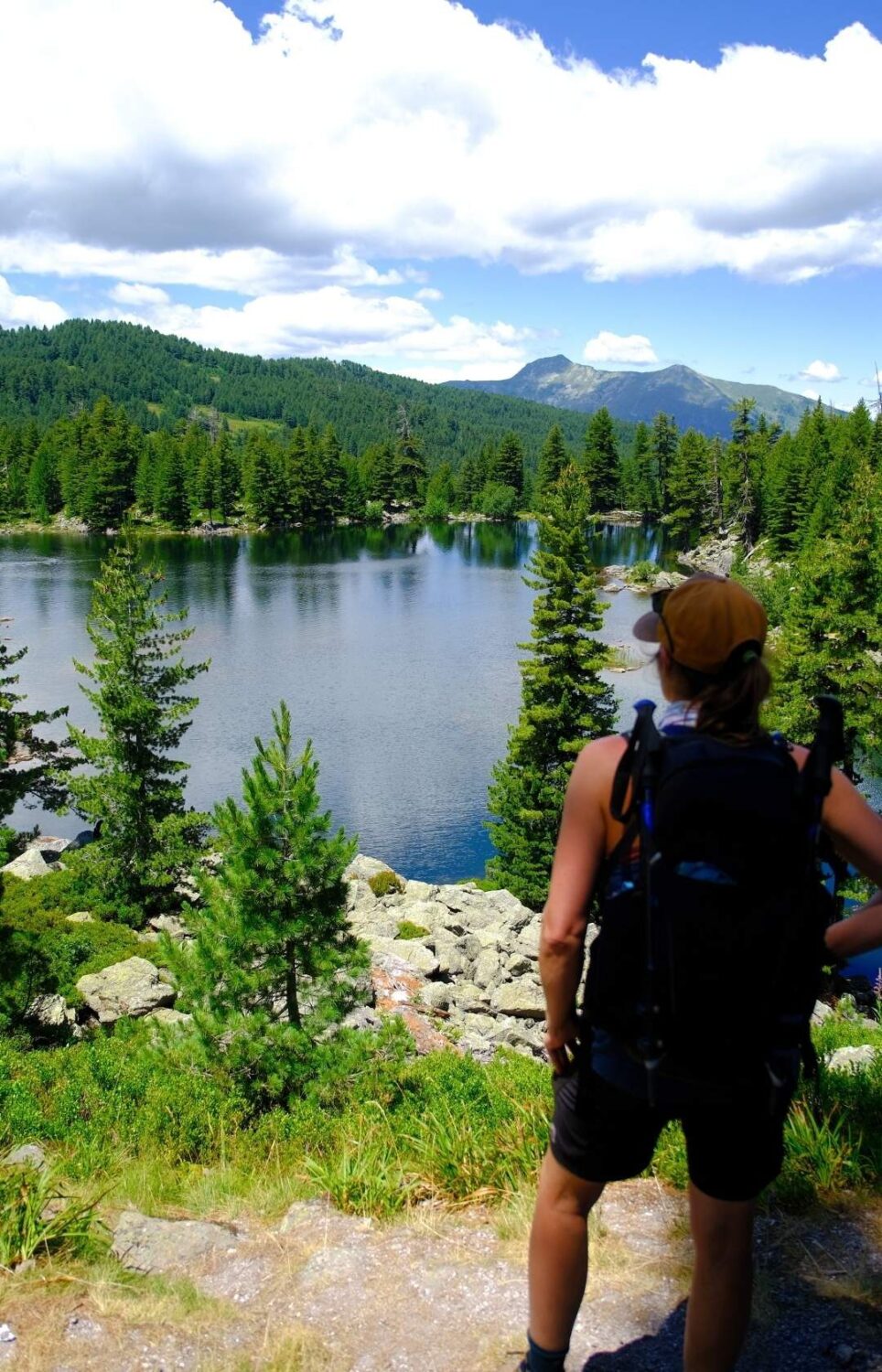 Wanderer, der während einer Wanderung auf dem Balkan nachdenklich den Blick auf den See genießt